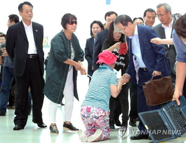 떠나는 홍준표..무릎꿇은 지지자(영종도=연합뉴스) 안정원 기자 = 홍준표 자유한국당 전 대표가 휴식을 위해 11일 미국으로 출국하기 위해 인천공항으로 들어서자 한 지지자가 무릎을 꿇고 악수하고 있다. 2018.7.11 jeong@yna.co.kr