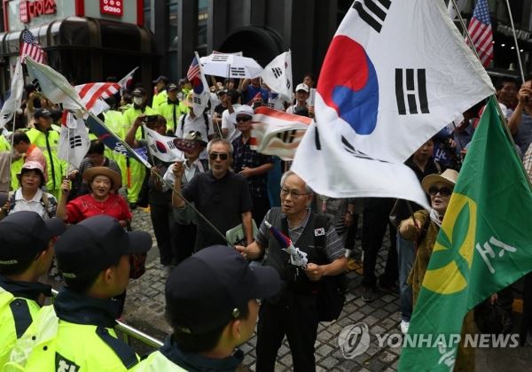 (서울=연합뉴스) 이지은 기자 = 김경수 경남도지사가 드루킹의 댓글조작 행위를 공모한 혐의로 특검에 출석한 6일 오전 서울 강남구 특검에 사무실 밖에서 보수단체 회원들이 태극기를 흔들고 있다. 2018.8.6 jieunlee@yna.co.kr