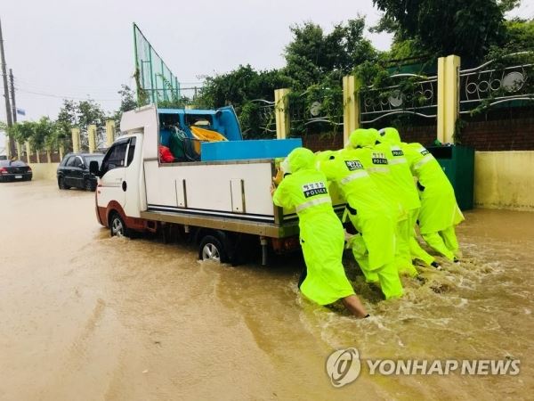 "으라차차" 물에 잠긴 차량 밀어내는 속초해경(속초=연합뉴스) 6일 호우경보가 내려진 강원 속초에 260.9㎜의 폭우가 쏟아져 주요 도심이 물바다로 변하자 속초해경 직원들이 물에 빠진 차량을 밀고 있다. 2018.8.6 [속초해경 제공]jlee@yna.co.kr