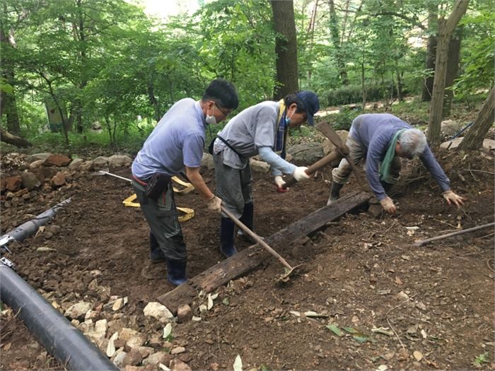 감로 선생님과 여동 선생님, 송정욱 도서관장님이 샘 아래의 터를 평평하게 만들고 있다.