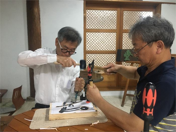 이완용(오른쪽) 선생이 필자의 서각 작업이 서툴자 옆에서 도와주고 있다. 사진=목압서사 제공