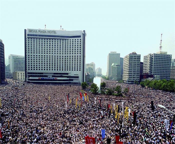 고 이한열을 추모하기 위한 군중들이 시청앞 광장과 소공로, 서소문 일대를 가득 메운 모습이다. 학원민주화 요구에서 비롯된 학생운동은 1980년대 중반 사회 민주화운동을 확산시키는데 중요한 역할을 하였다. 1987년 초 정부는 '4.13 호헌 조치'를 발표하였다. 이 선언을 계기로 학생과 시민은 직선제 개헌을 더욱 강력히 요구하였다. 같은해 6월 10일 민주헌법쟁취국민운동본부는 '박종철군 고문치사 조작은폐 규탄 및 호헌철폐 국민대회'를 개최하였다. 한달만에 전국적으로 연인원 500만명이 참가한 '6월 항쟁'이 시작되었다.(1987.07.09)